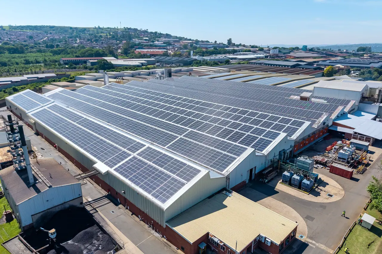 Aerial view of the Belgotex factory and its rooftop solar plant, with the hills of Pietermaritzburg beyond
