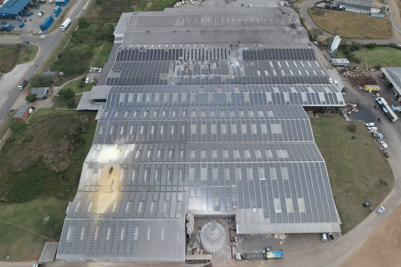 The Truda Foods factory in Pietermaritzburg from above, its roofs covered in solar modules, with grass and roads around it
